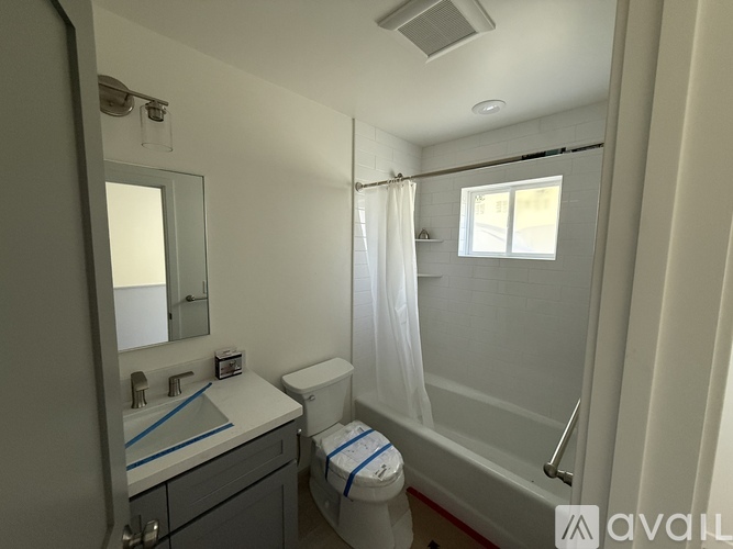 A bathroom with a toilet, sink, and shower.