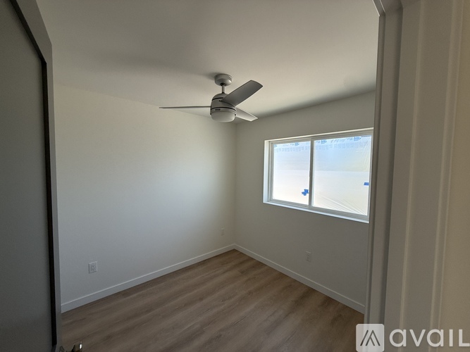 A room with a ceiling fan and a window.