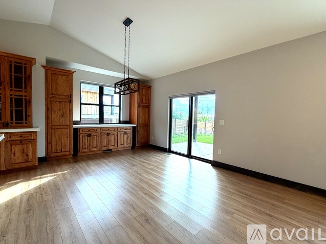 A spacious room with wooden floors and a large window.