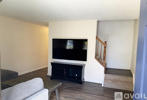 A living room with a grey couch and a black television.