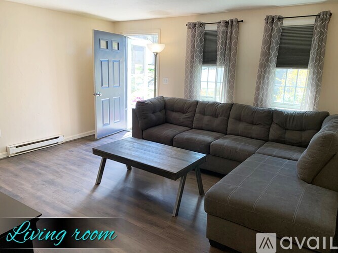 A living room with a grey couch and a wooden coffee table.