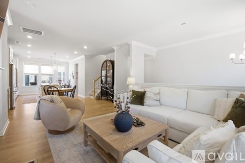 A living room with a white couch and a wooden coffee table.