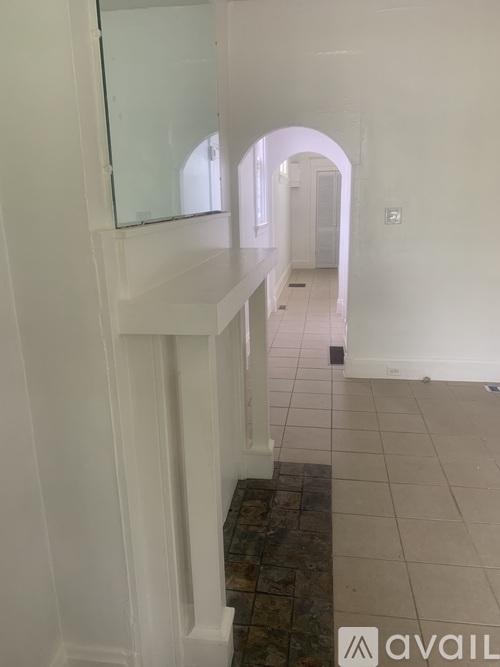 A hallway with a glass mirror on the wall.