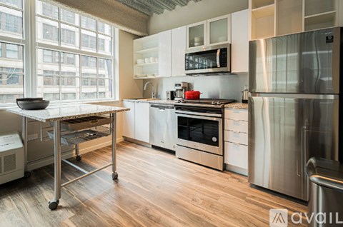 A kitchen with stainless steel appliances and wooden floors.