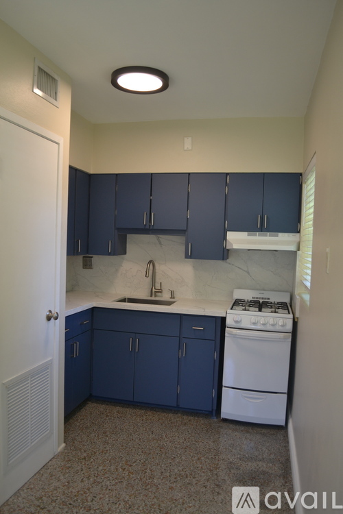 A kitchen with blue cabinets and a white stove.