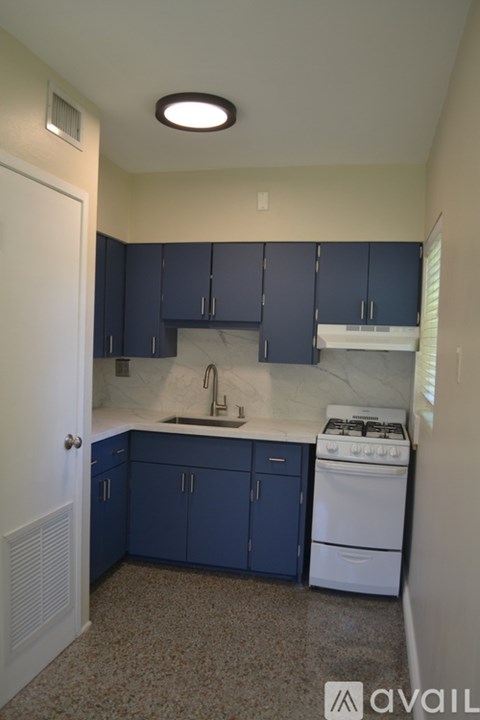 A kitchen with blue cabinets and a white stove.