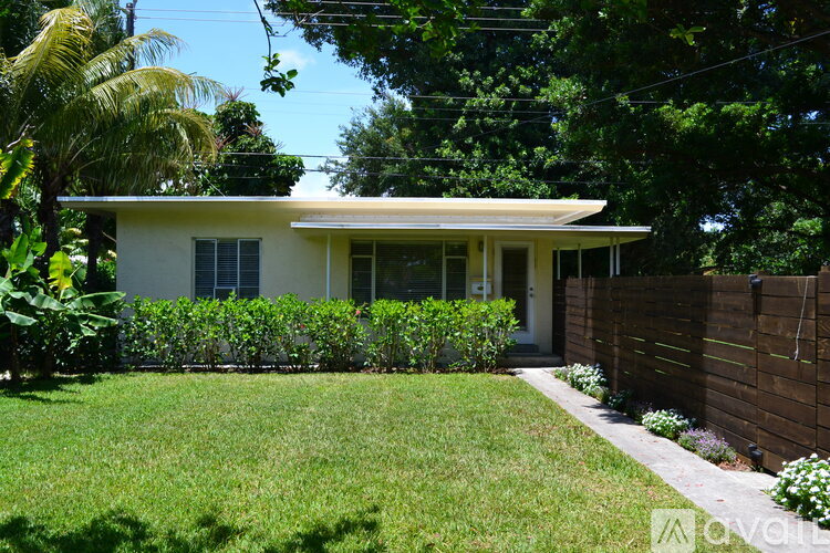 A house with a white exterior and a green lawn.