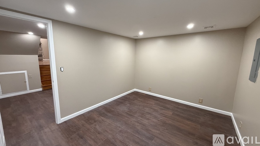 A room with wooden flooring and white walls.