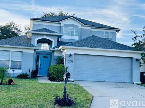 A house with a blue door and garage door is for sale.