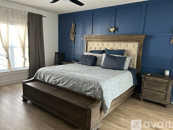 A bedroom with a large bed and a wooden dresser.