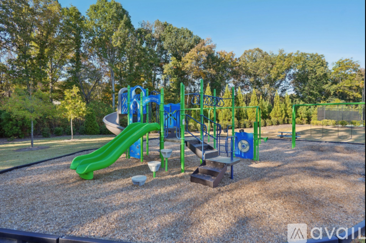A playground with a green slide and a blue swing set.