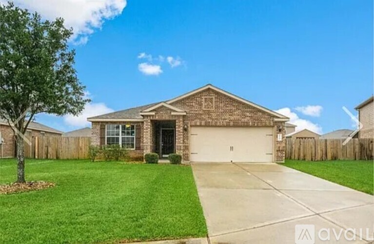 A house with a garage and a tree in front of it.