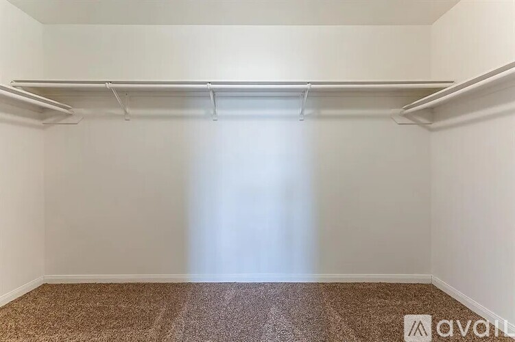 A room with a carpeted floor and a wall-mounted shelf.
