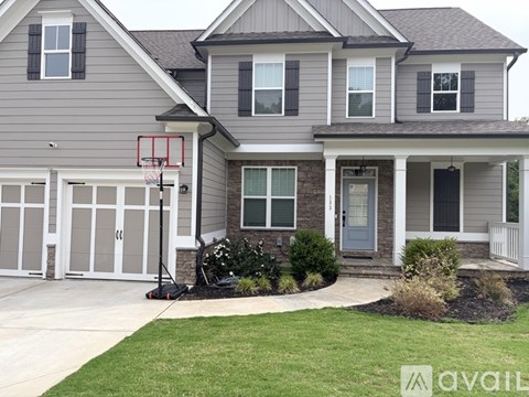 A house with a basketball hoop in the front yard.