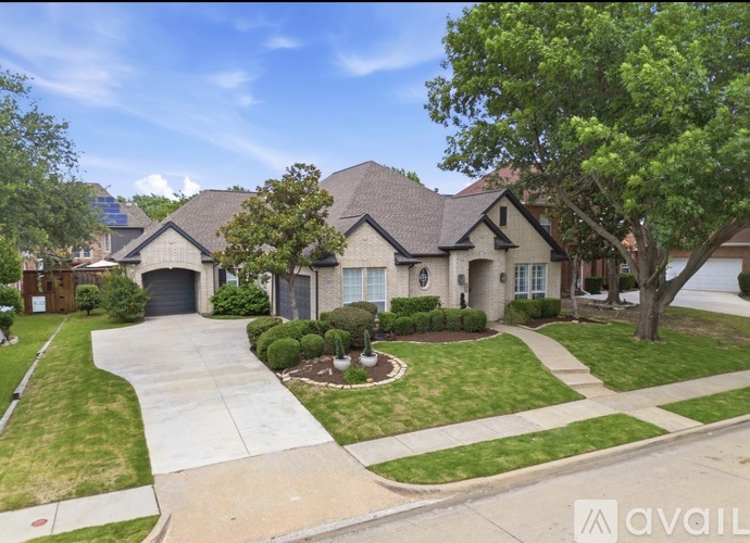 A house with a driveway and a tree in front.