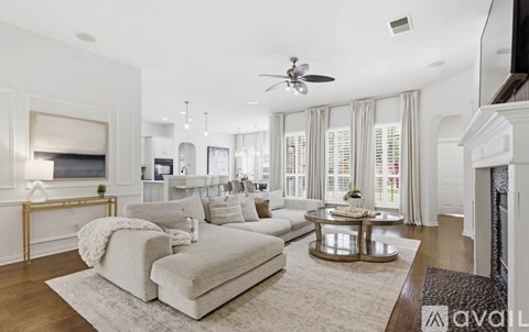 A living room with a white couch and a fireplace.