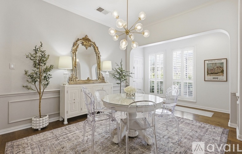 A white dining room with a round table and chairs.