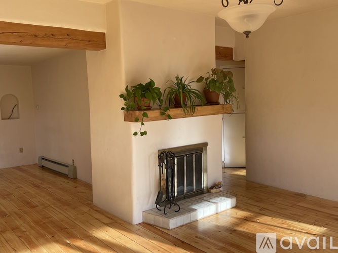 A living room with a fireplace and wooden floors.