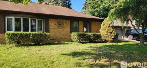 A house with a brown roof and a tree in front of it.