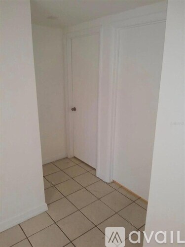 A room with white walls and tiled floor.