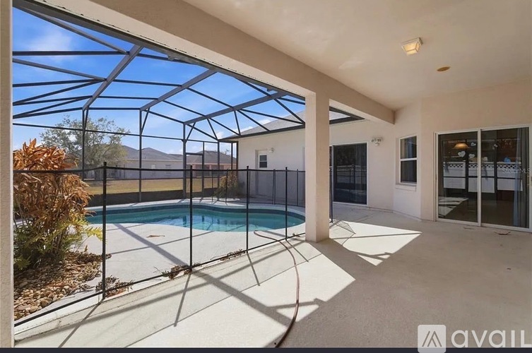 A sunny day at the pool with a glass enclosure.