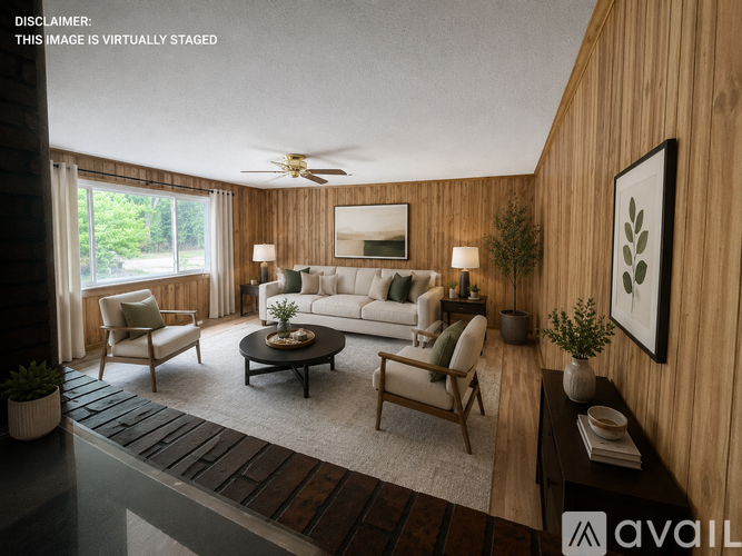 A living room with a white couch, a coffee table, and a ceiling fan.