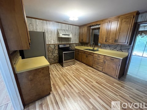 A kitchen with wooden cabinets and a stone backsplash.