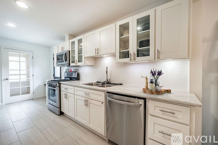 A kitchen with white cabinets and appliances.