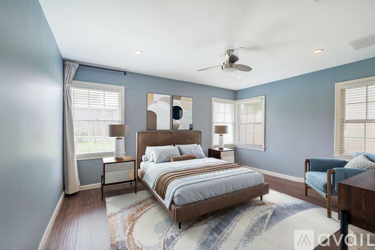 A bedroom with a large bed and a ceiling fan.