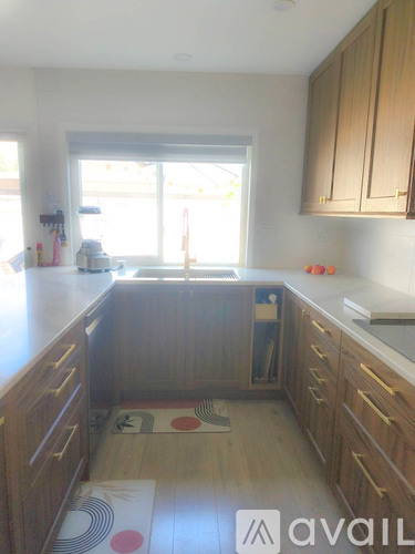 A kitchen with wooden cabinets and a window.