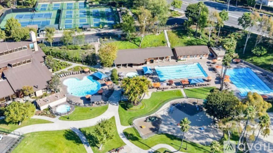 An aerial view of a resort with a swimming pool and tennis courts.