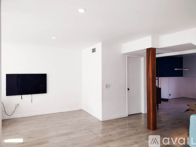 A modern living room with a flat screen TV mounted on the wall.