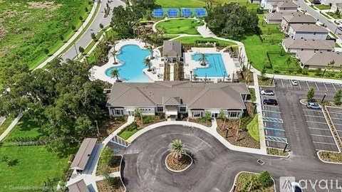 A bird's eye view of a resort with a swimming pool and a parking lot.
