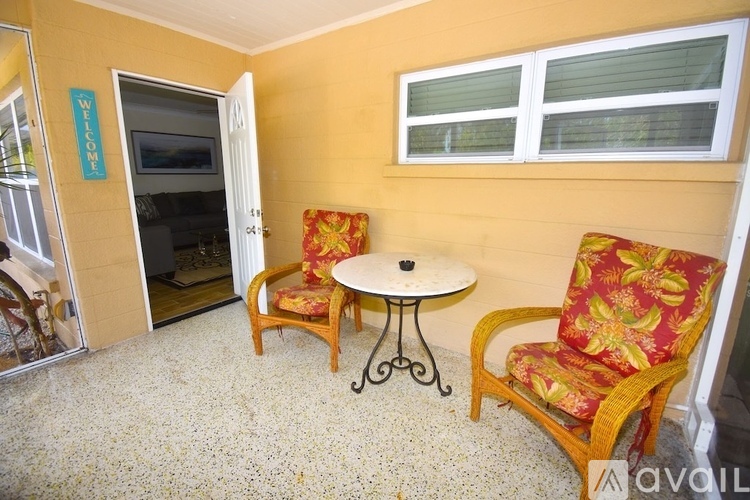A living room with a table and two chairs.