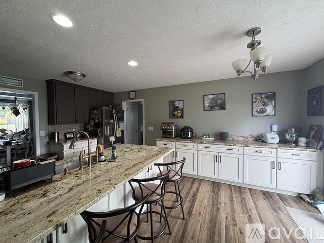 A kitchen with a long counter and chairs.