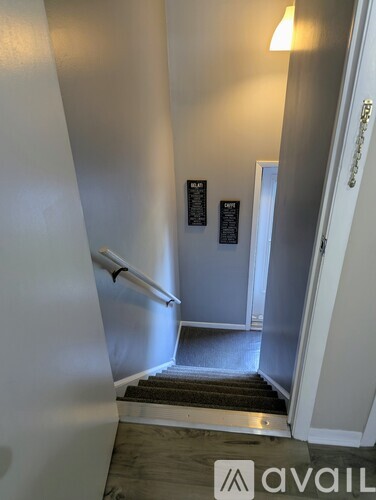 A hallway with a white door and a sign on the wall.