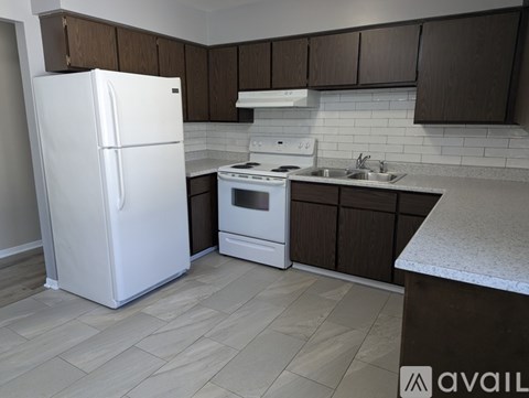 A kitchen with a white refrigerator and a white stove top oven.