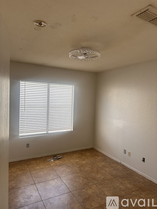 A room with a tiled floor and a window with blinds.