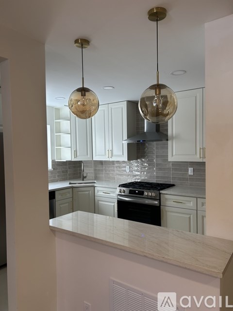 A kitchen with a white counter top and a black stove.