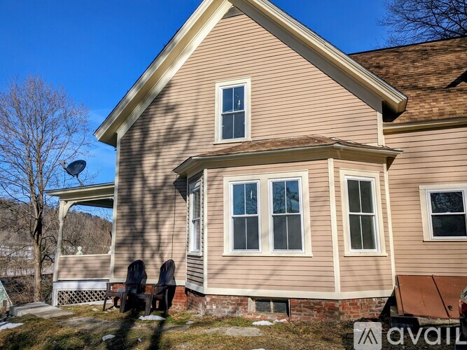 A house with a brown roof and beige siding is for sale.