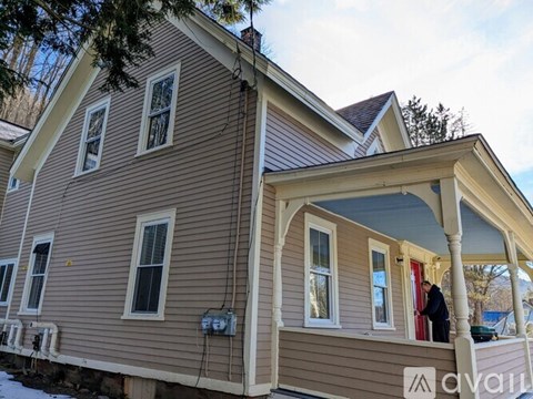 A house with a brown siding and a white trim.