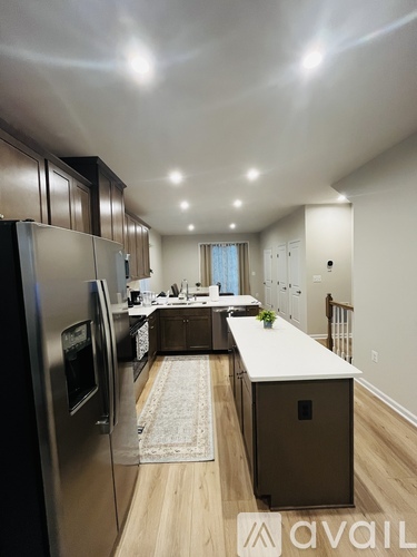 A kitchen with a refrigerator on the left and a counter on the right.