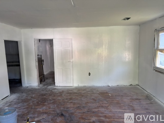 A room with a door and a window, and a floor with a lot of tiles.