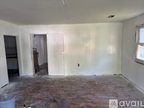 A room with a door and a window, and a floor with a lot of tiles.