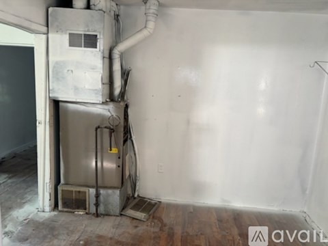 A dirty room with a furnace and air conditioner unit.