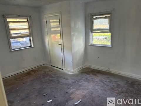 A room with a door, a window and a wall.