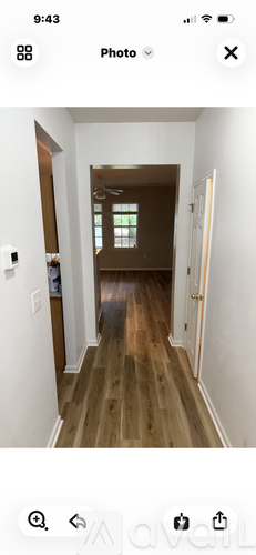 A long hallway with wooden floors and white walls.