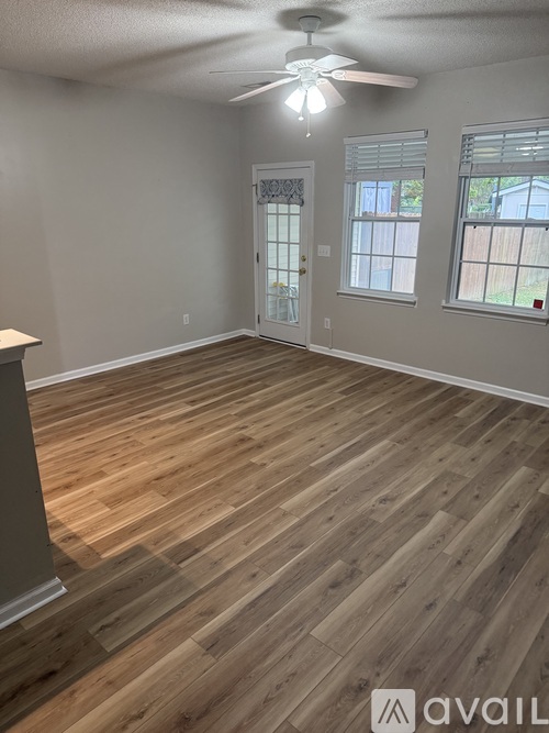 A room with wooden flooring and a ceiling fan.