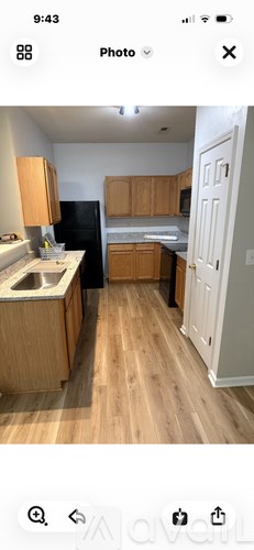 A kitchen with wooden cabinets and a black refrigerator.