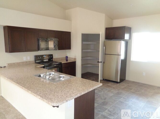 A kitchen with brown cabinets and a granite countertop.